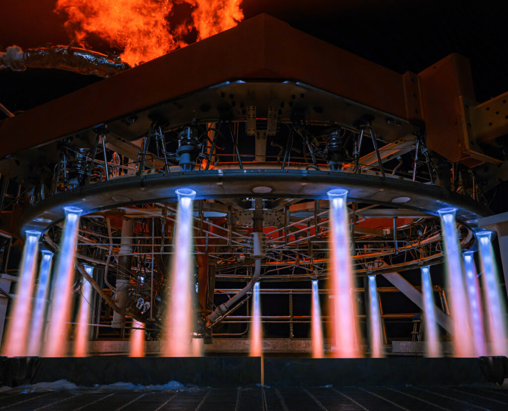 Stoke Space's innovative rocket engine performing a nighttime test firing, showcasing its unique distributed thruster system with an integrated heat shield, as part of their mission to develop fully reusable rockets for sustainable space travel
